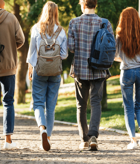 Four University of Oregon students walking through park